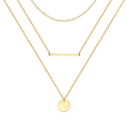 Layered gold necklace with fine chains, bar pendant and round disc charm