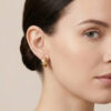 Gold huggie hoop earrings with bezel-set clear crystal accents