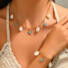 Gold paperclip chain necklace with cream shells and turquoise-blue starfish charms