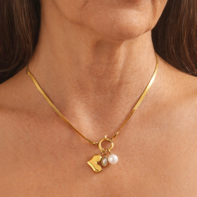Gold charm necklace with letter charm, pearl and crystal pendant on a mature woman’s neck, elegant everyday jewellery for women over 50.