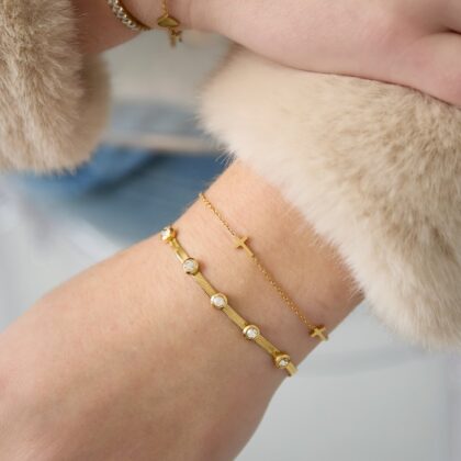 herringbone Gold herringbone bracelet with small bezel-set crystals and adjustable clasp on white background