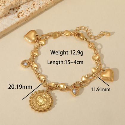 Gold heart charm bracelet with zircon detail and layered chains on white background