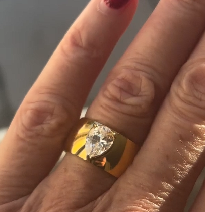 Gold droplet statement ring with zircon stone worn on hand with red nail polish