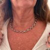 woman wearing a silver stainless steel chain necklace close-up on neck and collarbone