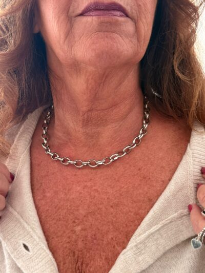 woman wearing a silver stainless steel chain necklace close-up on neck and collarbone