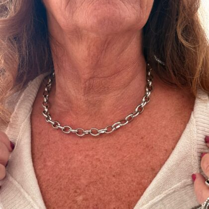 woman wearing a silver stainless steel chain necklace close-up on neck and collarbone