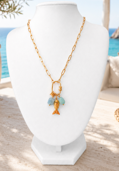 Ibiza fish necklace Gold stainless steel Ibiza fish necklace with blue charms on white mannequin against Ibiza beach background.