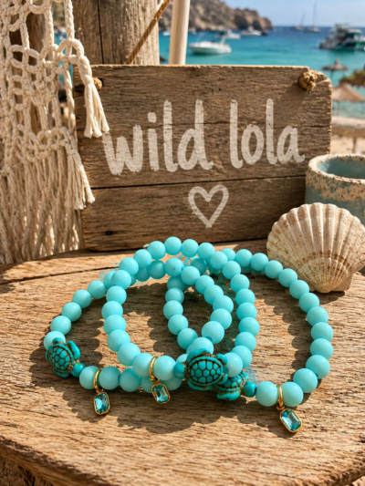 Handmade aqua elastic bracelet with sea turtle charm and crystal detail displayed on a beach-inspired boho background.