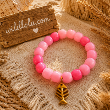 💗 Wild Lola Fishbone Bracelet – Pink Handmade colorful acrylic bead bracelet with a gold fishbone charm displayed on a boho beach-inspired background.