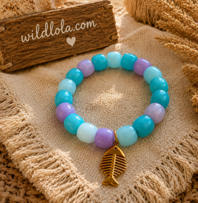 π Wild Lola Fishbone Bracelet Lavender Beach Handmade colorful acrylic bead bracelet with a gold fishbone charm displayed on a boho beach-inspired background.