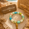 Wild Lola Ocean Treasure Bracelet β Large Fit Large-fit turquoise and seafoam stretch bracelet with crackle beads and gold fish charm by Wild Lola.