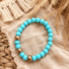 beads3 Soft blue elastic bracelet with acrylic beads and gold accents styled on a neutral boho background