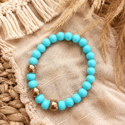 beads3 Soft blue elastic bracelet with acrylic beads and gold accents styled on a neutral boho background