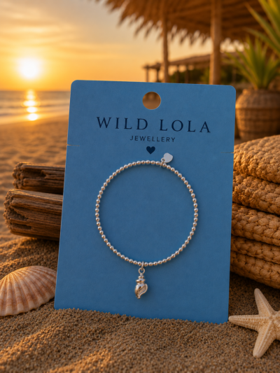 Sweet7 silver stainless steel elastic beaded bracelet with shell charm.