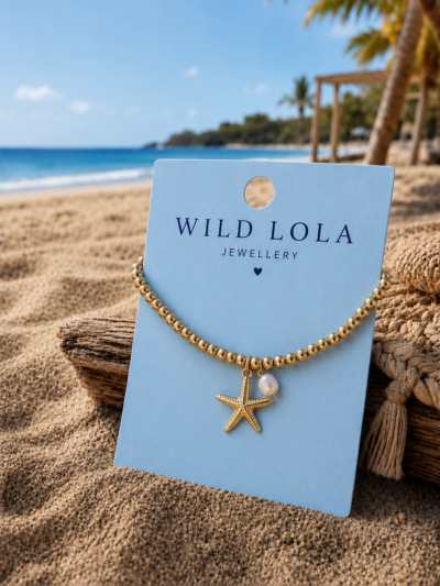 Starfish Shell Bracelet β Gold Stainless Steel Gold elastic bracelet with stainless steel beads, starfish charm and shell detail displayed on a beach-inspired background.